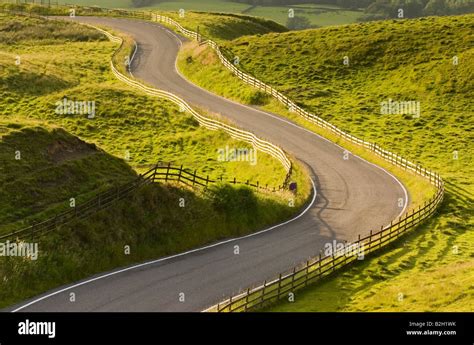 A Road Winding Its Way Through Green Hilly Landscape Stock Photo Alamy