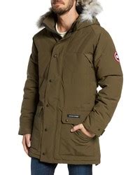 Comment porter une parka olive avec un pantalon chino à rayures