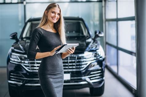 Free Photo | Female salesperson at a car showroom by the car