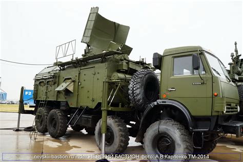 An Army Truck Is Parked On The Pavement In Front Of Another Vehicle