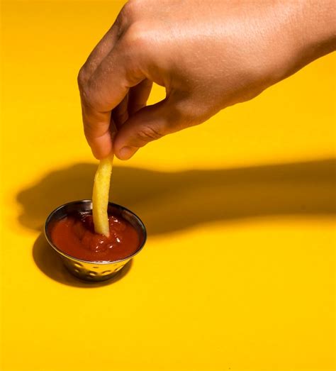 Free Photo Close Up Dipping French Fry In Ketchup