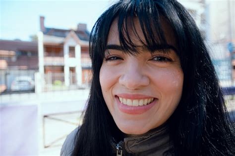 Retrato de primer plano en ángulo de una joven latina sonriendo mirando