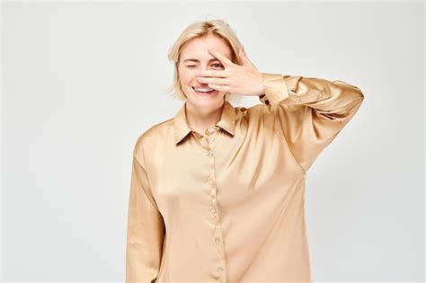 Portrait D Une Jeune Femme Blonde Couvrant Les Yeux Avec La Main Regardant Travers Les Doigts