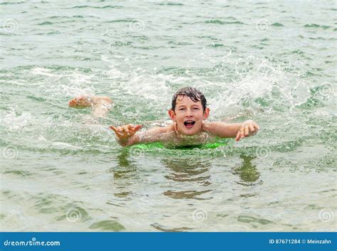 El Muchacho Feliz Goza El Practicar Surf En Las Ondas Foto De Archivo