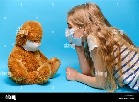 Masked Blonde Girl Talking To Masked Teddy Bear Quarantine Concept Stock Photo Alamy