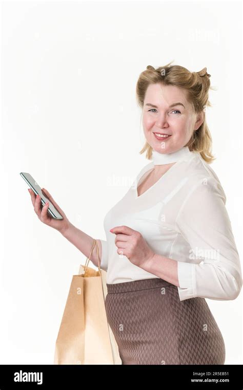 Blonde Woman Shopper Using Mobile Phone And Holding Shopping Bags On