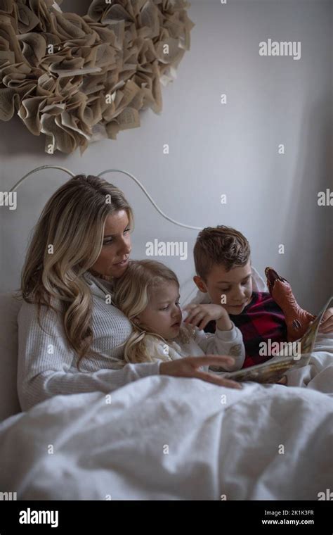 Madre Leyendo El Cuento De Acostarse Al Hijo Y A La Hija En La Cama