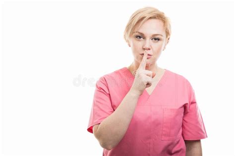 Attractive Female Nurse Wearing Pink Scrubs Making Silent Gesture Stock