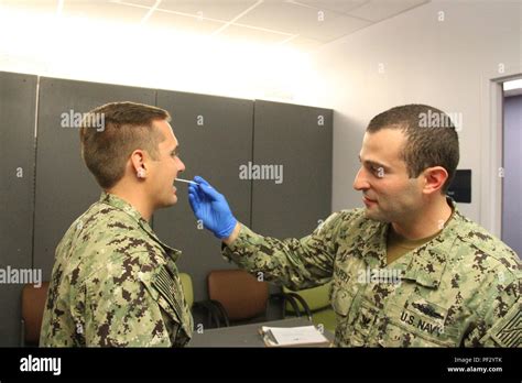 Hospital Corpsman Second Class Eric Halpert Swabs The Cheek Of A