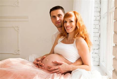 Husband Sitting On The Floor Pregnant Woman On A Chair The Husband