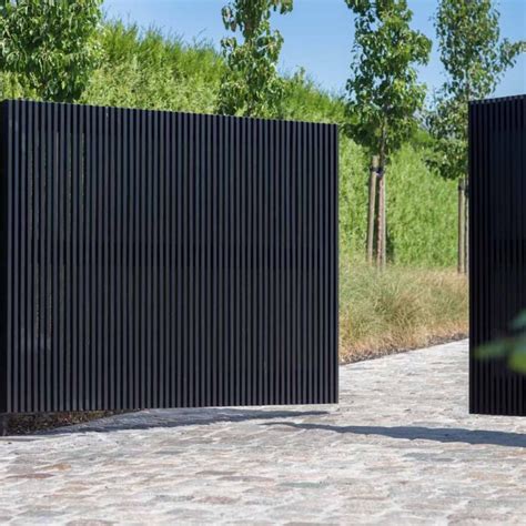 Two Black Metal Gates Sitting Next To Each Other On A Brick Walkway In