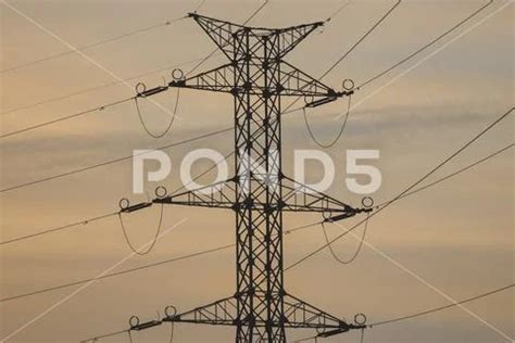 High Voltage Power Transmission Towers In Sunset Sky Background Hi