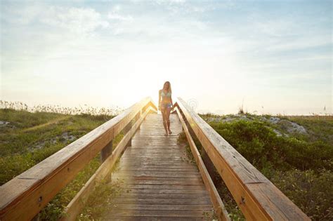 El Puente Hacia La Playa Una Joven En Bikini En Un Paseo Cerca De La Playa Foto De Archivo