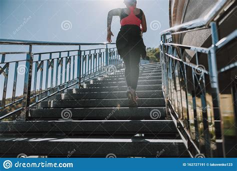 Afro American Young Woman Running Up The Stairs Outdoors Stock Image