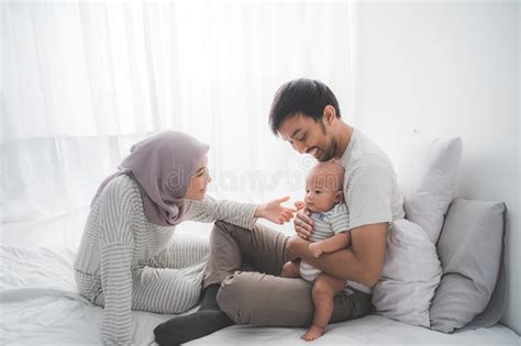 Muslim Parent With Their Newborn Baby Enjoy Time Together Stock Photo