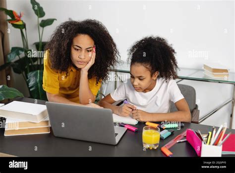 Mère afro américaine aidant sa fille à faire ses devoirs Concept de