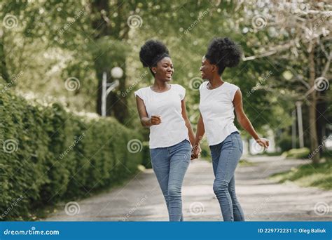 Twin Sisters Holding Hands And Walking In A Park Stock Image Image Of