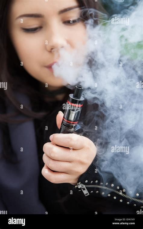 Young Brunette Girl Vaping Smoke Clouds With Popular Vaporizer Device E