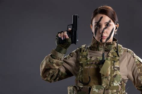 Portrait de femme soldat en uniforme militaire avec arme à feu sur le