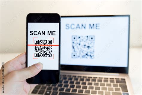 Using a smartphone app to scan a QR code. Man's hand uses a mobile phone application to scan QR ...