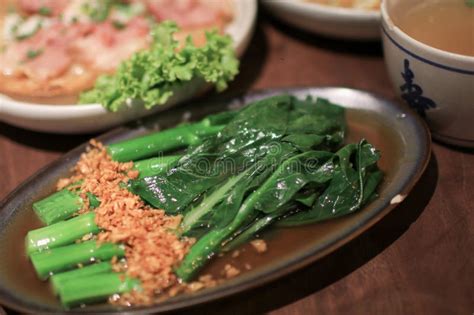 Kale Fried In Oyster Sauce With Garlic On Wooden Table Chinese Kailan