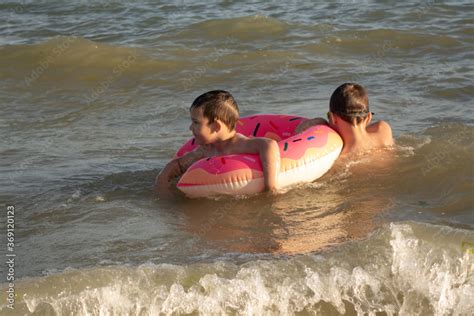 A 5 Year Old Boy Swims In The Sea With A Donut Shaped Inflatable Circle