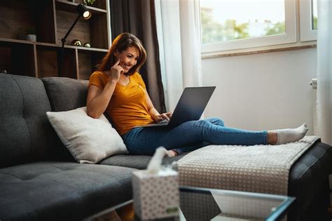 Atractiva Mujer Joven Sentada En El Sof Y Usando Su Computadora