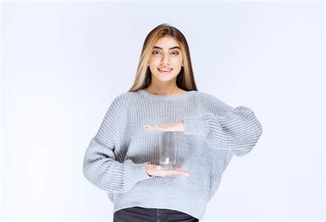 Chica En Sudadera Gris Sosteniendo Un Vaso De Agua Pura Foto Gratis