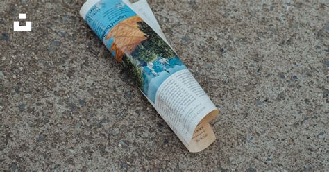 A Rolled Up Newspaper Laying On The Ground Photo Free City Sidewalk