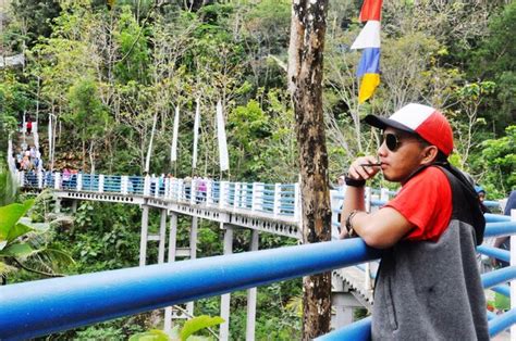 Premium Photo Man Wearing Cap Standing By Railing On Bridge