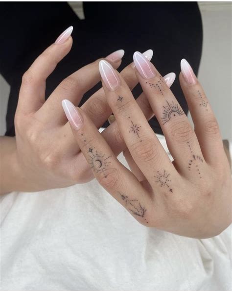 A Woman S Hand With Tattoos On It And Two Fingers In The Shape Of Stars