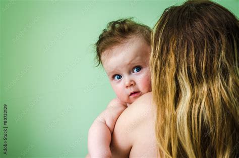 Naked Girl Baby On The Shoulder Of Mothers On A Green Background Stock Photo Adobe Stock