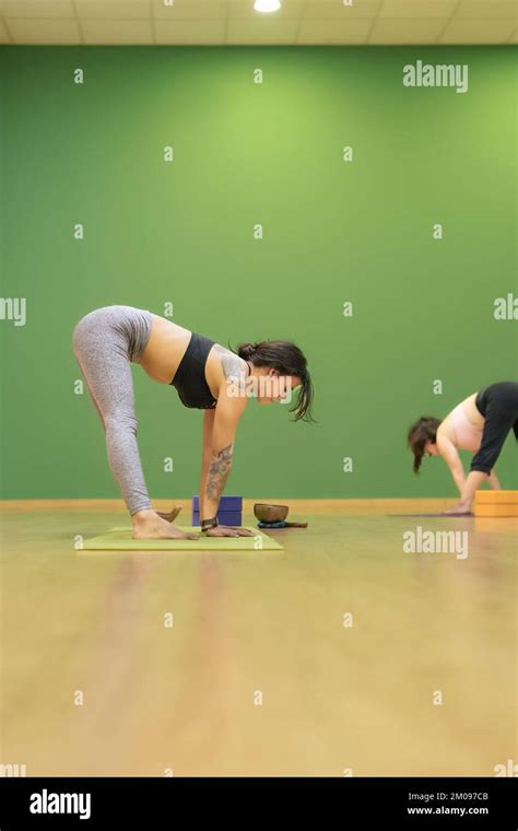 Vertical Photo Of Young Yoga Teacher Teaching Yoga Classes With The Prasarita Padottanasana A