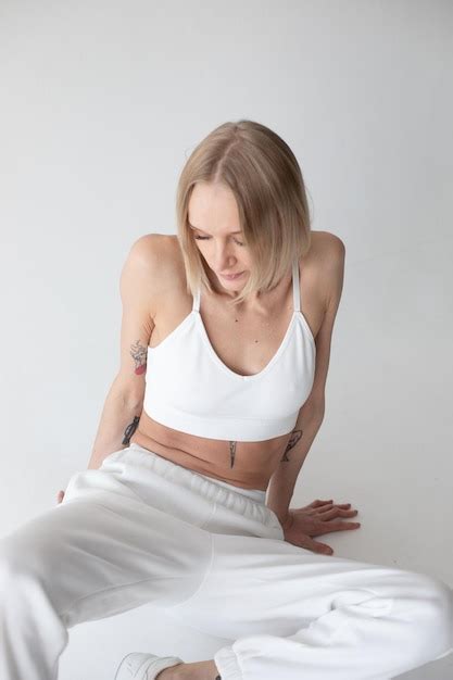 Premium Photo Beautiful Blonde Girl In A White Top And Tights Posing On A White Background
