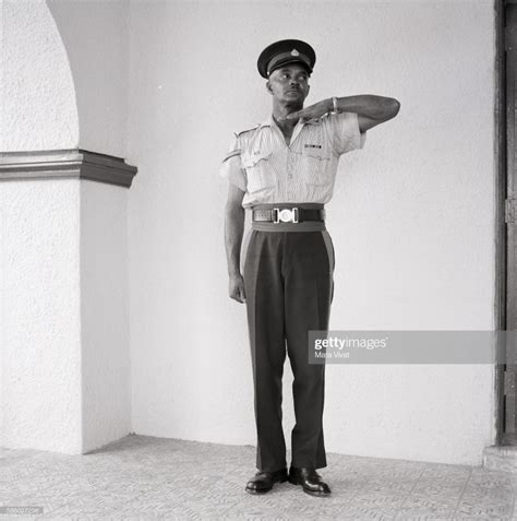 A Jamaican police officer stands guard wearing an official uniform ...