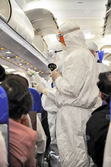 Medics In White Protective Suits Checking And Scanning Passengers In A