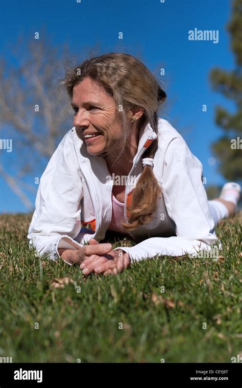 Mature Woman Laying In Grass In A Park Smiling Stock Photo Alamy