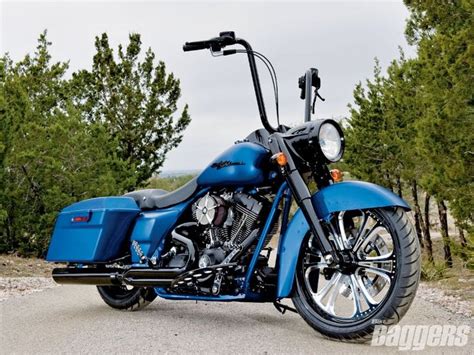 A Blue Motorcycle Parked On Top Of A Gravel Road