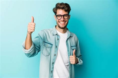 Premium Photo | Portrait of man doing thumbs up on blue isolated background