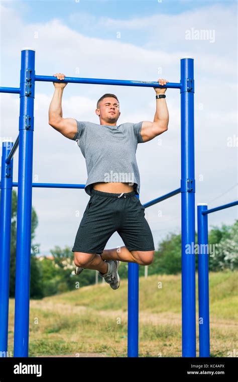 Masculine Man Doing Pull Ups On Street Workout Outdoors Stock Photo Alamy