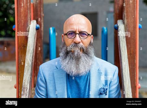 Male Middle Aged Balding Bearded Man Sitting In A Park Relaxing