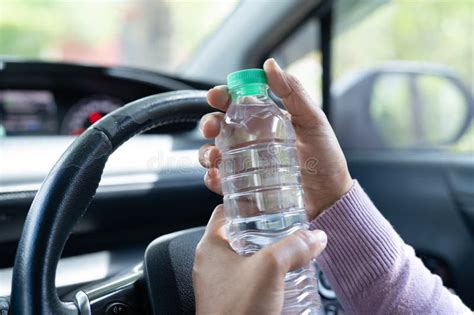 Asian Woman Driver Holding Bottle For Drink Water While Driving A Car Plastic Hot Water Bottle
