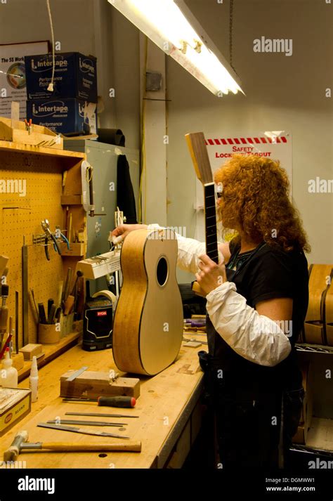 Woman Gluing The Neck To The Guitar Body During Production Process At