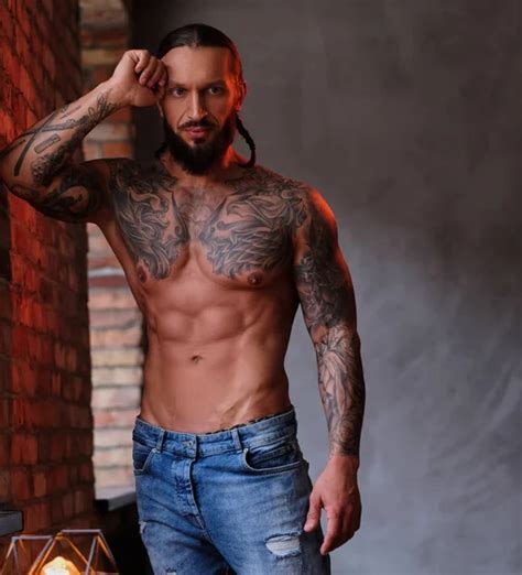 Pensive Shirtless Bearded Male With The Muscular And Tattooed Body