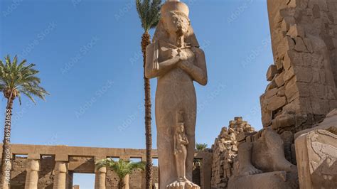 The ancient statue of Pharaoh Ramses in the Karnak Temple of Luxor. A tall figure against a ...