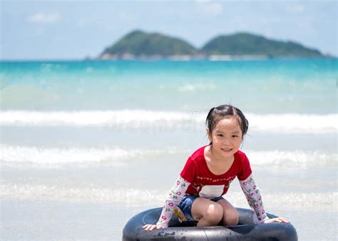 Le Petit Jeu Asiatique De Course De Fille Ondule Sur La Plage Image