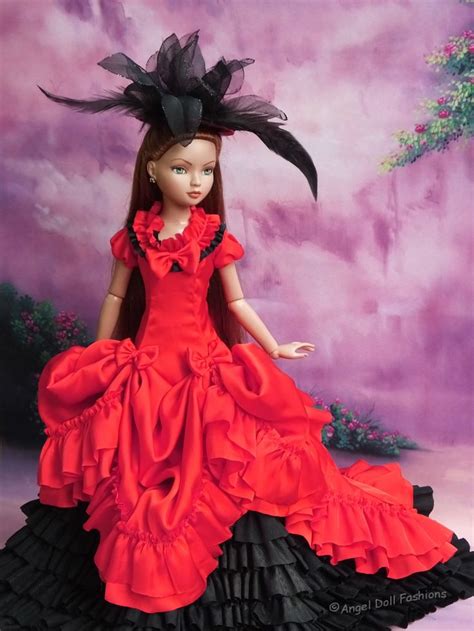 A Doll Wearing A Red Dress With Black Ruffles And A Hat On Her Head