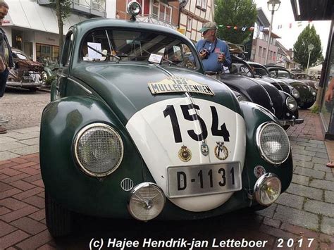 An Old Green And White Car Is Parked On The Street