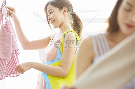 服装店挑选衣服的年轻女子高清图片下载 正版图片502278636 摄图网