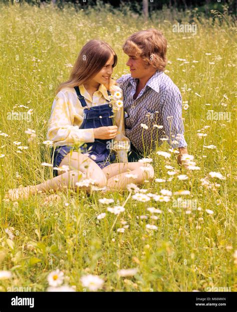 1970s ROMANTIC TEENAGE COUPLE SITTING IN A FIELD OF DAISIES - kj6265 ...